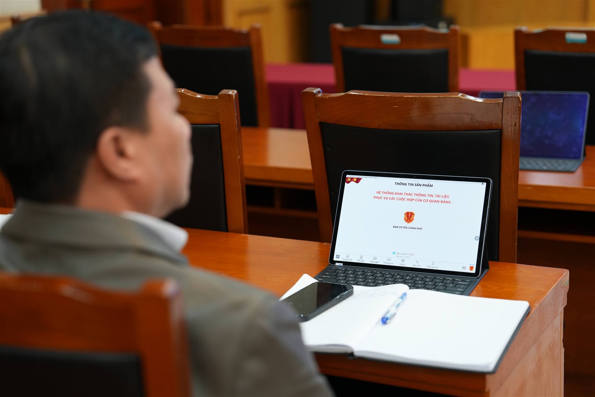 Cán bộ sử dụng máy tính bảng tra cứu tài liệu phục vụ cuộc họp